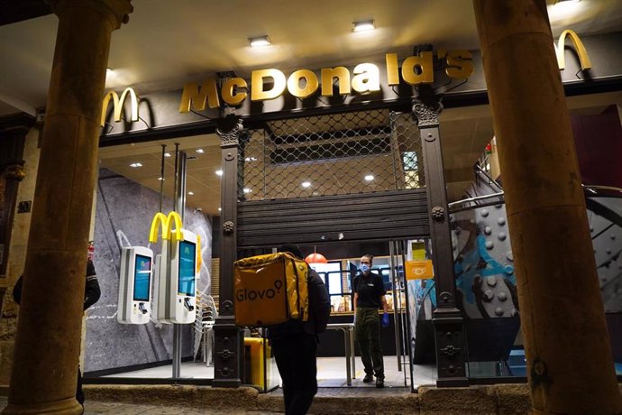 Un trabajador de Glovo entra en un McDonald's en Salamanca la noche en la que la ciudad ha vivido su primer toque de queda dictado por la Junta de Castilla y León para toda la región
