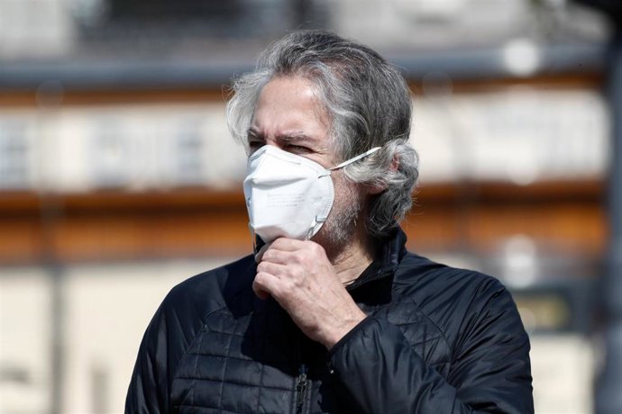 Un hombre con mascarilla pasea por la calle.