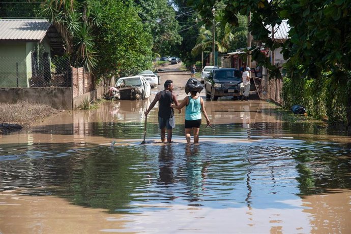 Una pareja anda por una calle anegada tras el paso de 'Eta' por Honduras. 