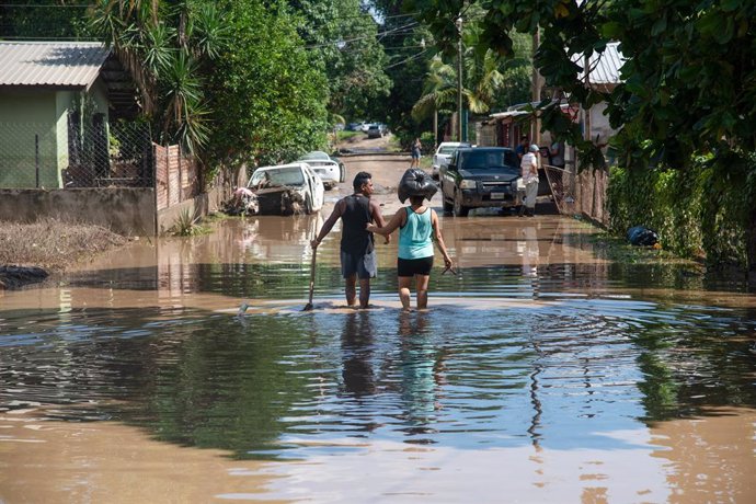 08 November 2020, Honduras, San Pedro Sula: A couple wade through a flooded street, days after Hurricane Eta hit the region. Photo: Seth Sidney Berry/SOPA Images via ZUMA Wire/dpa