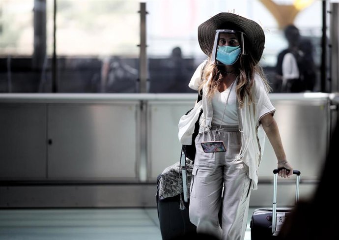 Una pasajera protegida con mascarilla en un aerouerto de España.