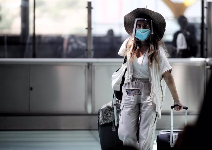 Una pasajera protegida con mascarilla en un aerouerto de España.