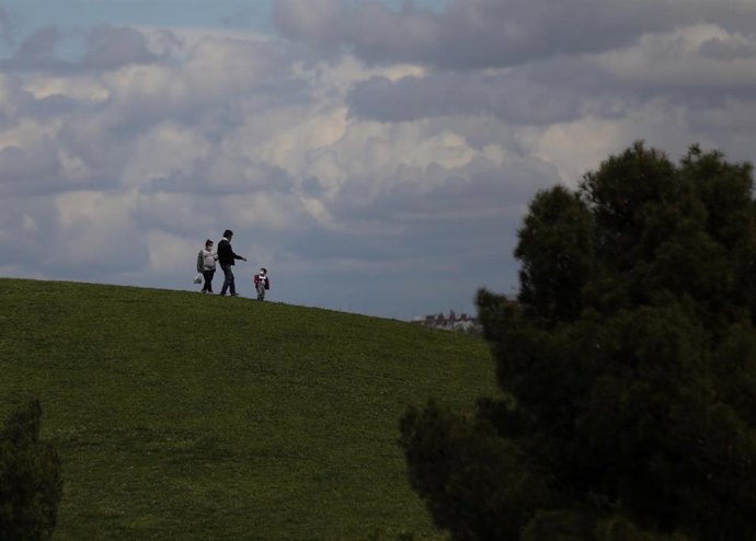 Un niño pasea con sus padres. En Madrid (España) a 27 de abril de 2020.