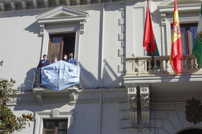 La fachada del Ayuntamiento de Granada luce una mascarilla de gran tamaño en el marco de una campaña de sensibilización sobre la Covid-19