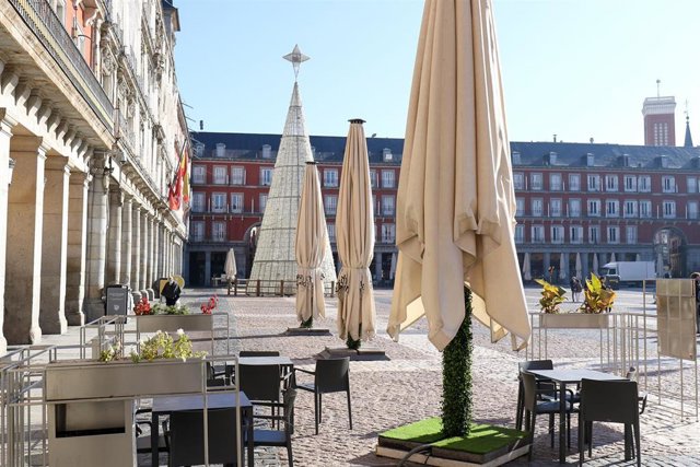 Las terrazas totalmente vacías con el árbol de Navidad de fondo en la plaza Mayor, en Madrid.