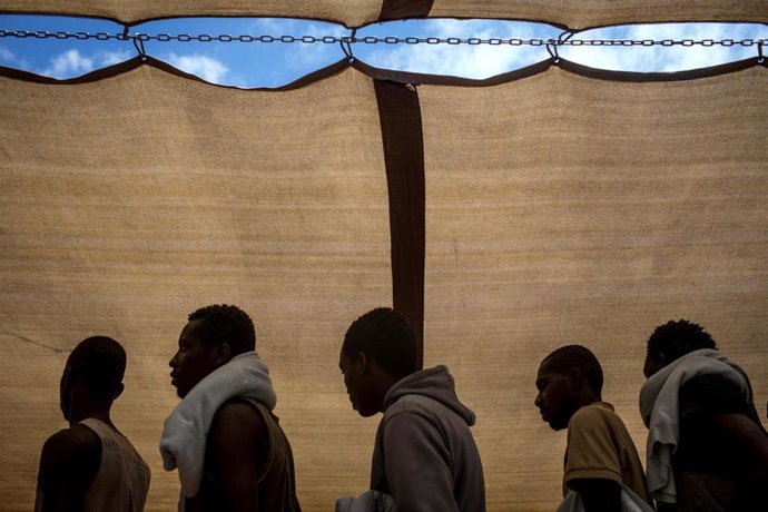 Refugiados y migrantes rescatados en el mar Mediterráneo a la espera de desembarcar en Italia