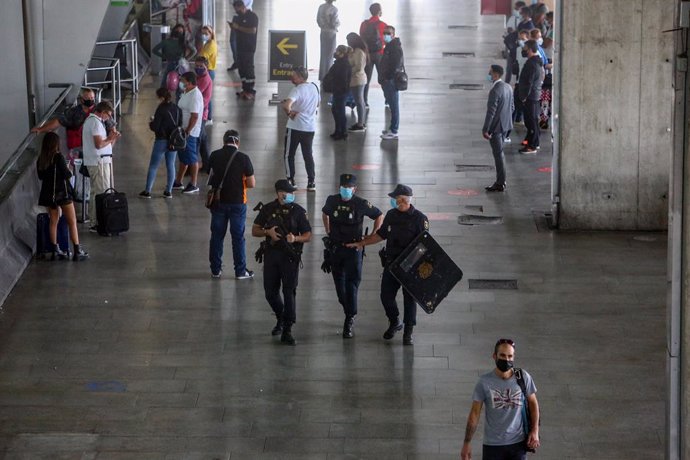 Agentes de Policía Nacional vigilan la T4 del Aeropuerto Adolfo Suárez Madrid-Barajas, en Madrid (España), a 9 de octubre de 2020. El Ministerio del Interior ha comenzado a desplegar un amplio operativo de controles policiales en Madrid y el resto de mu