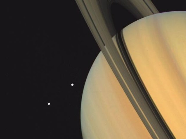 Imagen de Saturno y sus lunas Tethys y Dione tomada por Voyager 1 ek 3 de noviembre de 1980