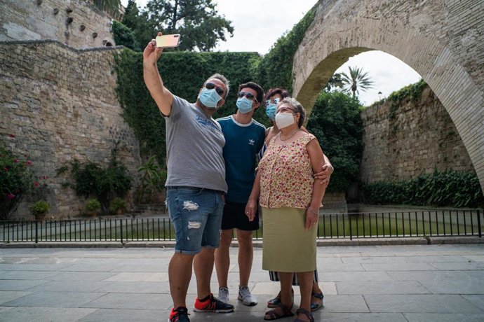 Varios turistas se hacen una foto junto a los Jardines de S'Hort del Rei de Palma.