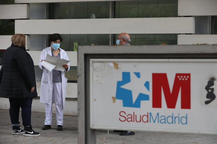 Una trabajadora sanitaria habla con varias pacientes que esperan en la puerta del Centro de Salud Doctor Tamames