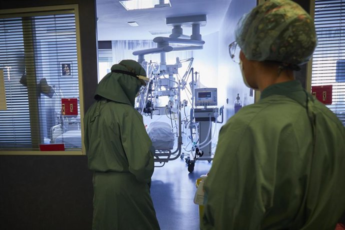 Una trabajadora sanitaria se dispone a entrar para atender a un paciente de una habitación de la UCI de la Clínica Universidad de Navarra, en Pamplona