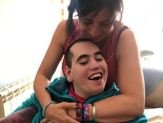 Una madre, Lola, abraza a su hijo, Luis, con parálisis cerebral