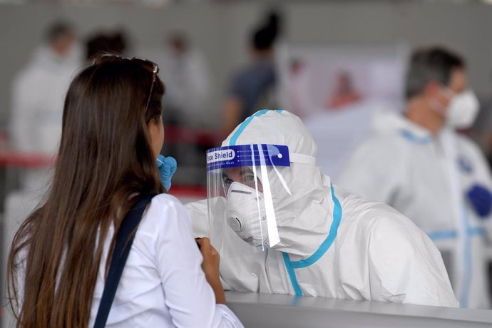 16 September 2020, Austria, Vienna: A health worker takes a swab from a student at a Coronavirus (Covid-19) test lane at the Austria Center Vienna. Photo: Roland Schlager/APA/dpa