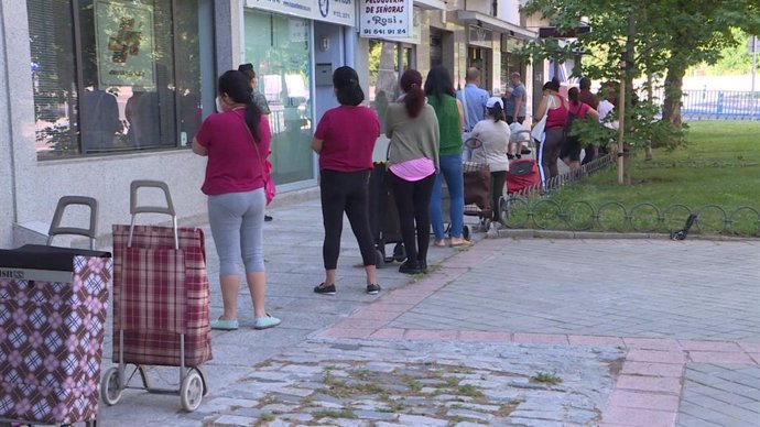 Cola de personas esperando a recibir alimentos y productos de primera necesidad, repartidos por la asociación de vecinos Manzanares-Casa de Campo a familias vulnerables.
