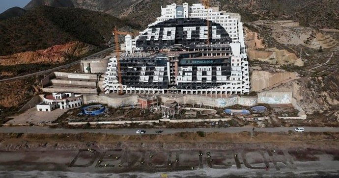     Una veintena de activistas de la organización Greenpeace han escrito con letras gigantes la palabra 'Demolición' a primera hora de este martes en la playa frente al hotel de El Algarrobico, en Carboneras (Almería), en el día en el que se conmemoran 