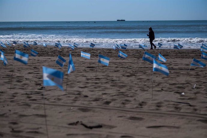 Banderas conmemorativas en recuerdo de las víctimas del coronavirus en una playa argentina.