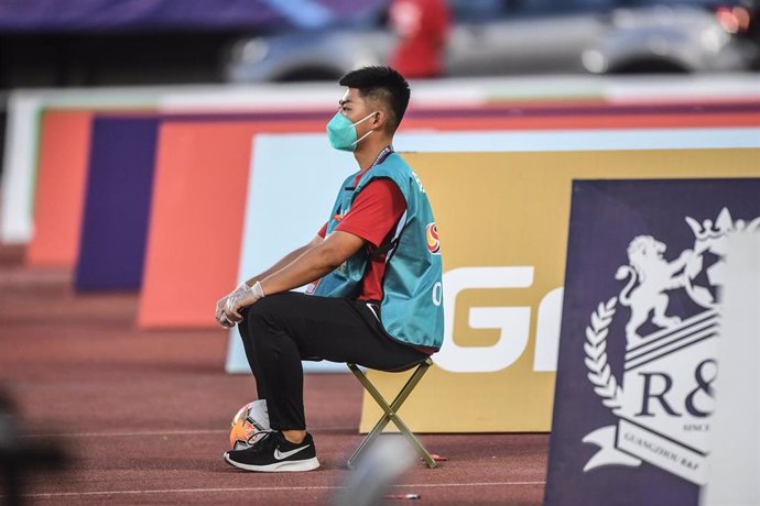 Un recogepelotas durante un partido de la liga china de fútbol.