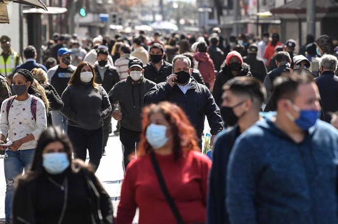 Personas con mascarilla en una calle de Santiago, en Chile