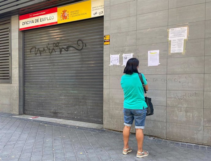 Una persona observa uno de los carteles con instrucciones para hacer trámites por internet colocados en la fachada de una oficina del SEPE el día en el que se conocen los datos del paro de junio, en Madrid (España), a 2 de julio de 2020. 