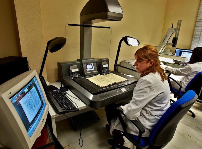 Una archivera digitaliza un documento.