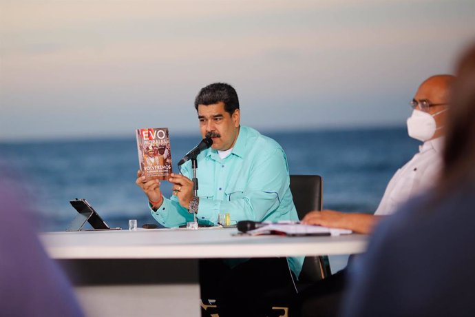 HANDOUT - 25 October 2020, Venezuela, La Guaira: Venezuelan President Nicolas Maduro holds a book by Bolivian former President Evo Morales while giving a speech at a government event in La Guaira. Photo: Jhonn Zerpa/Prensa Miraflores/dpa - ATTENTION: ed
