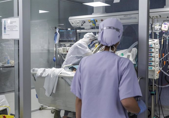 Trabajadores sanitarios totalmente protegidos atienden a un paciente con coronavirus ingresado en la UCI del Hospital Arnau de Vilanova, en Valencia, Comunidad Valenciana, (España), a 24 de abril de 2020.
