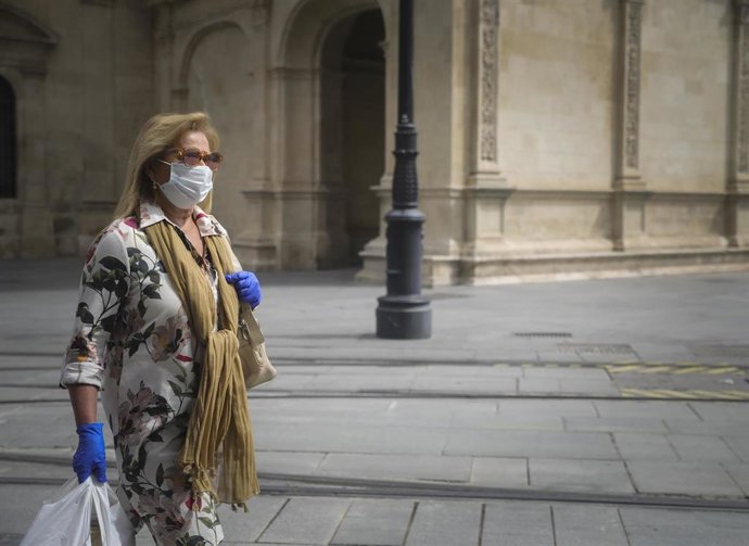 Una mujer caminando protegida con mascarilla y guantes durante el día 37 del estado de alarma en el país por la crisis del coronavirus. En Sevilla (Andalucía, España), a 20 de abril de 2020.
