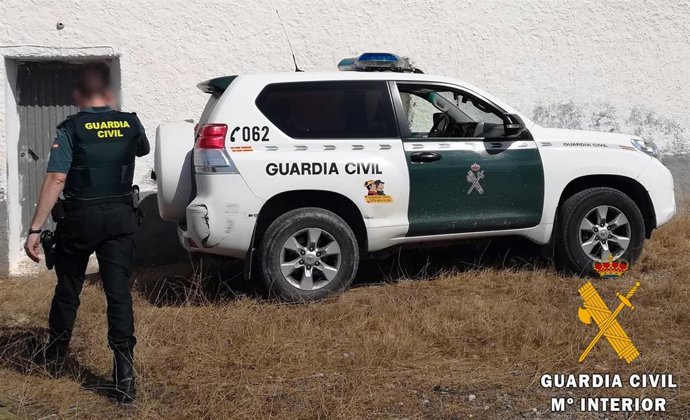 Un agente de la Guardia Civil junto a un coche