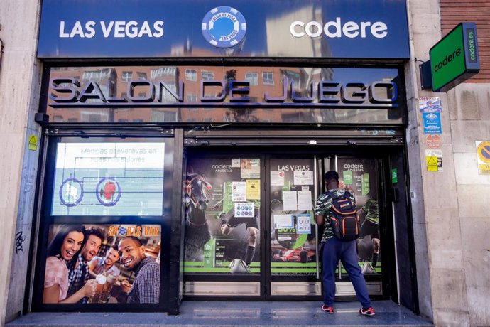 Un hombre se para frente a un salón de juegos 
