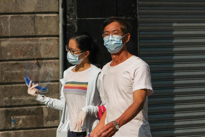 Una pareja con mascarilla pasea por las calles de Ciudad de México