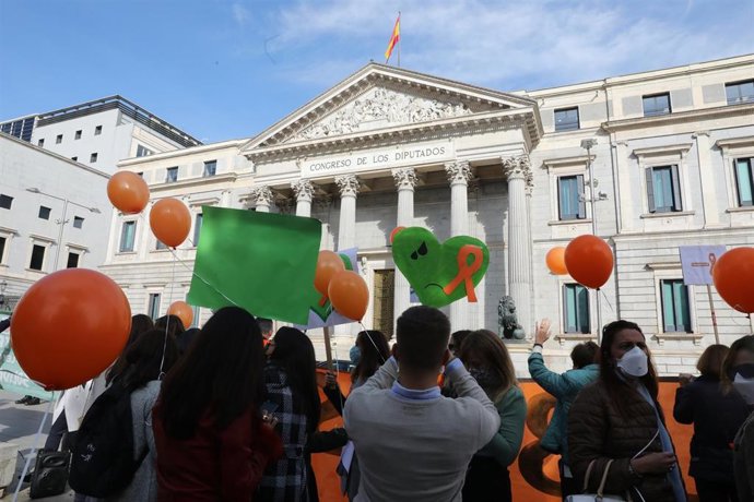 Varias personas portan globos naranjas durante una nueva concentración convocada ante el Congreso contra la LOMLOE, la reforma de la ley educativa conocida como 'ley Celaá', en Madrid, (España), a 13 de noviembre de 2020. La manifestación convocada por 