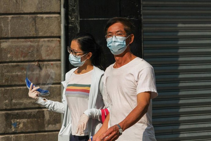 Una pareja con mascarilla pasea por las calles de Ciudad de México