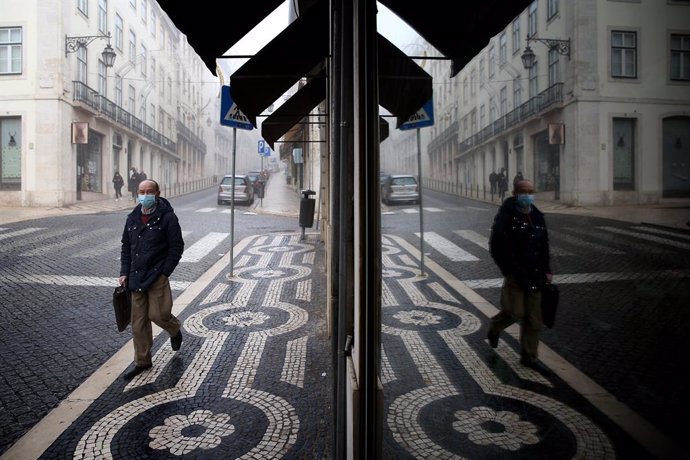09 November 2020, Portugal, Lisbon: A man wearing a face mask reflected in a shop glass as he walks in downtown Lisbon. Portugal returned to the state of emergency until 23 November amid the rising numbers of Coronavirus infections. Photo: Pedro Fiuza/Z