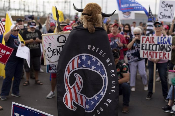 06 November 2020, US, Phoenix: A man wearing a cape referencing to QAnon, a far-right conspiracy theory,  speaks as supporters of US President Donald Trump gather during a protest in front of the Maricopa County Tabulation and Election Center as the cou