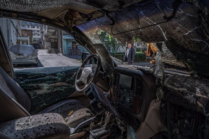 FILED - 13 October 2020, Azerbaijan, Stepanakert: A man looks at a damaged car after a shelling over the city of Stepanakert, amid the fighting between Armenia and Azerbaijan over the breakaway region of Nagorno-Karabakh, also known as Artsakh. Photo: C