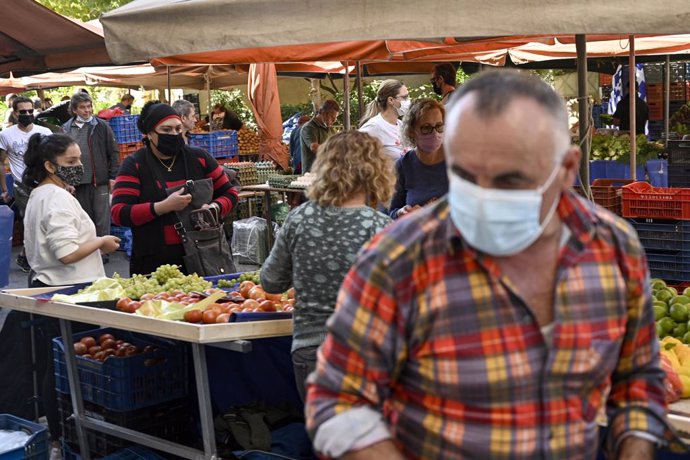 Personas con mascarilla en un mercadillo de Atenas, Grecia