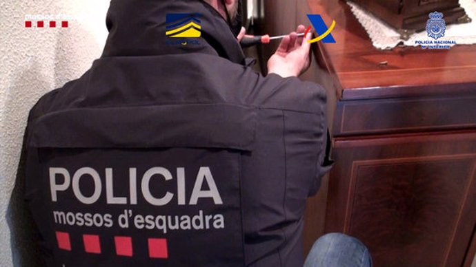 Un agent dels Mossos d'Esquadra en un dels escorcolls domiciliaris a l'organització criminal dedicada al contraban d'armes i explosius (Horitzontal).