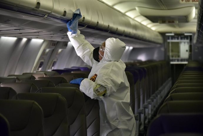 Un trabajador limpia el interior de un avión en el aeropuerto de Bogotá