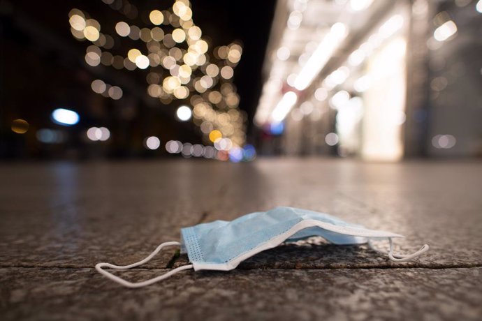 03 November 2020, North Rhine-Westphalia, Duesseldorf: A face mask lies on the sidewalk. Public life in Germany has been brought to a near-standstill as part of a four-week shutdown in Europe's largest economy in a bid to stem a surge in coronavirus inf