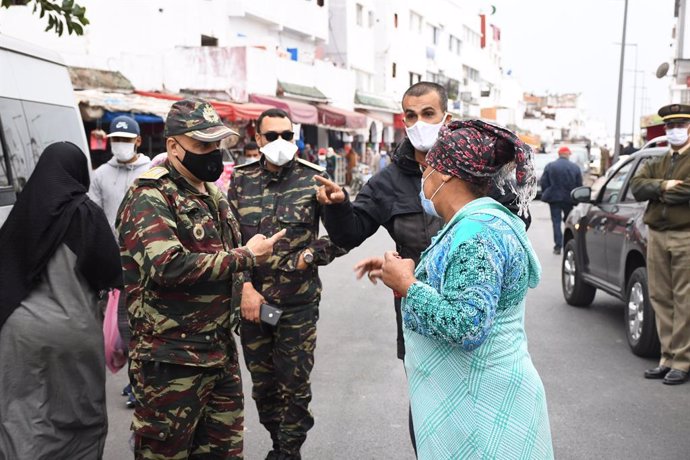 Miembros de las fuerzas de seguridad junto a otras personas con mascarilla en Rabat, Marruecos