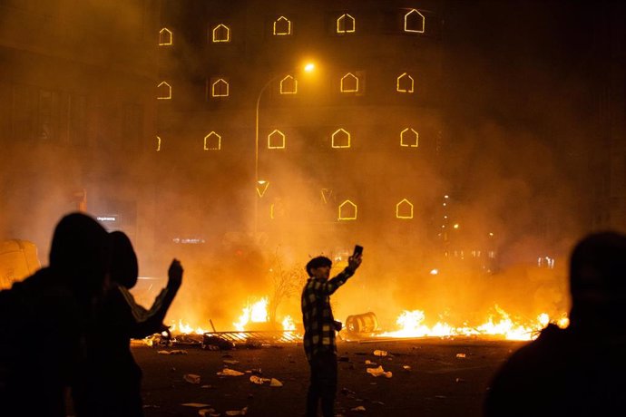 Manifestantes frente al fuego durante los disturbios en la Plaza de Urquinaona, en Barcelona a 18 de octubre de 2019.