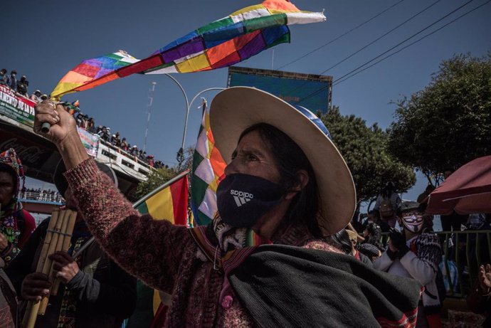 28 July 2020, Bolivia, El Alto: A woman waves the Wiphala flag, representing some native peoples of the Andes, during a protest against the renewed postponement of the general elections. The Supreme Electoral Court had postponed the elections scheduled 