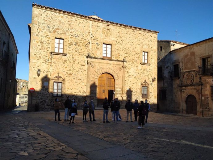 Un grupo de turistas con mascarilla visita la parte antigua de Cáceres