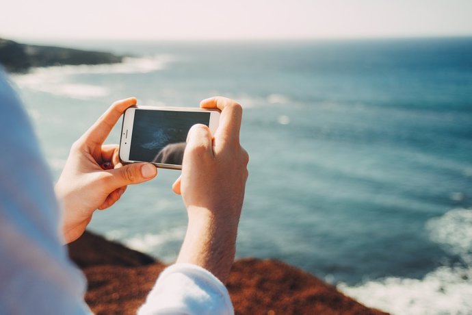 Una persona realiza una foto del mar con su teléfono móvil.