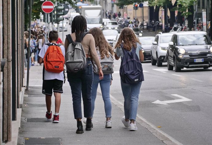 Estudiantes caminando por una calle.