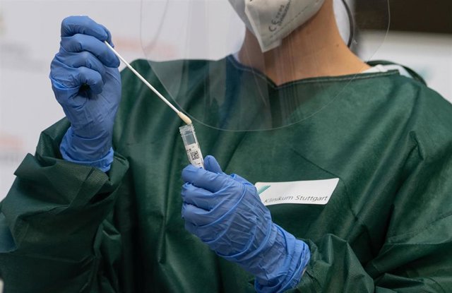 16 November 2020, Baden-Wuerttemberg, Stuttgart: A medic holds a test swab before analysing it during the presentation of the Rhonda PCR COVID-19 rapid test from the Freiburg-based medical technology start-up Spindiag and the Hahn-Schickard Institute for 