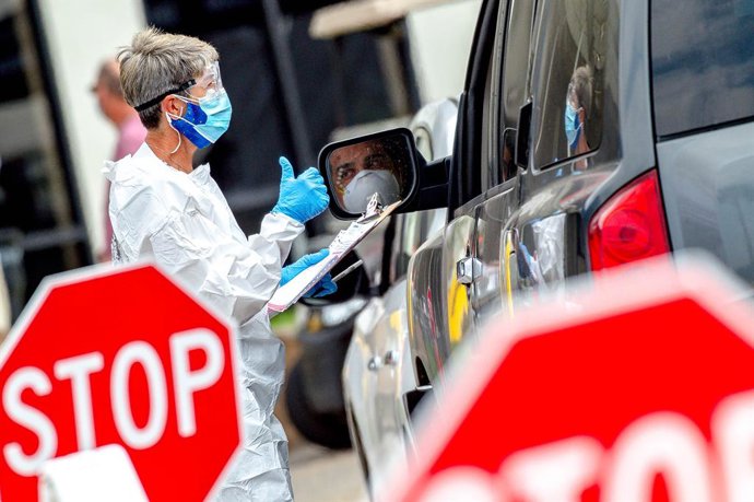 12 May 2020, US, Fontana: A health worker gestures after screening a driver during a coronavirus drive-thru testing at the Auto Club Speedway. Photo: Watchara Phomicinda/Orange County Register via ZUMA/dpa