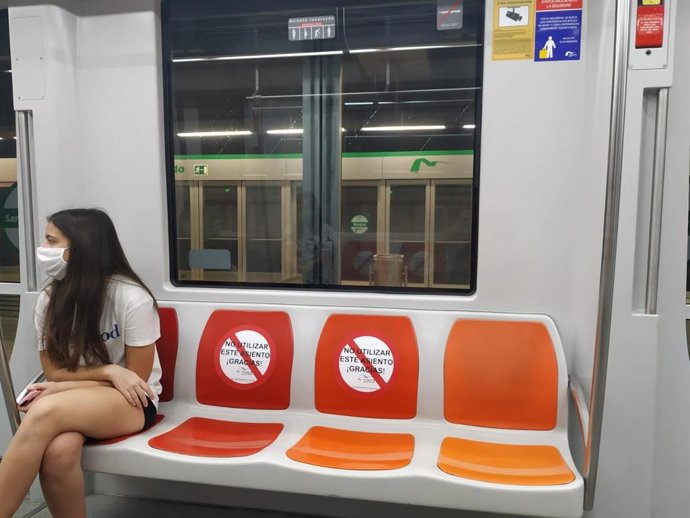 Una joven con mascarilla viaja en el Metro de Sevilla
