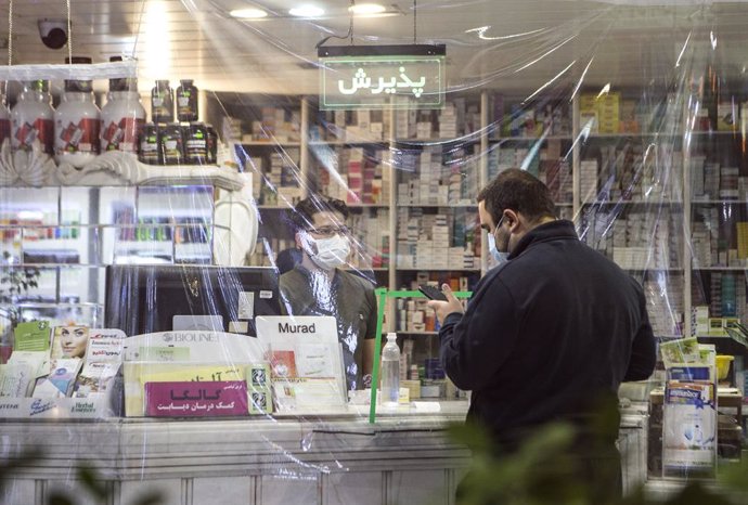 Personas con mascarilla en una farmacia de Mashhad, Irán