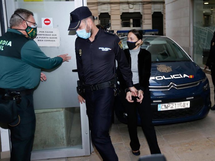 Custodiada por un agente de la Policía Nacional, la acusada de asesinar presuntamente al hijo de acogida de su pareja en la localidad alicantina de Elda, se dirige al del Juzgado de Instrucción número 2 de Elda, Alicante. 